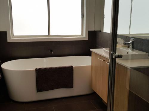 a bathroom with a bath tub and a sink at Adagio at Lonsdale in Point Lonsdale