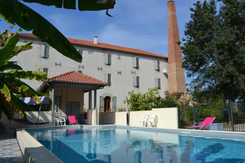 a swimming pool in front of a villa at Moulin de Saint Laurent in Saint-Laurent