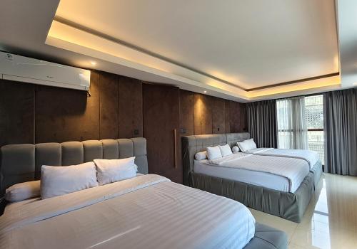 a hotel room with two beds in a room at Ohana Suites Yogyakarta in Yogyakarta