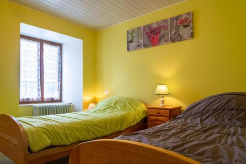 two beds in a room with yellow walls at Gîte de montchamp in Arzenc-dʼApcher