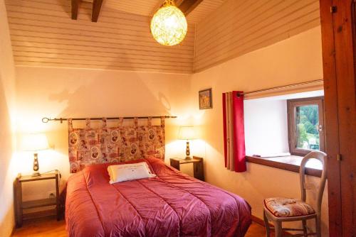 a bedroom with a red bed and a window at La grange - 4/6 personnes in Saint-Pierre-de-Nogaret