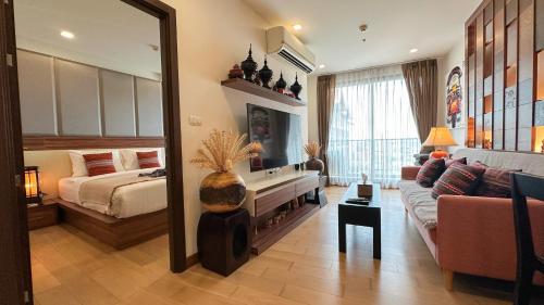 a living room with a couch and a bed and a mirror at The Astra Chang Khlan Chiang Mai in Chiang Mai
