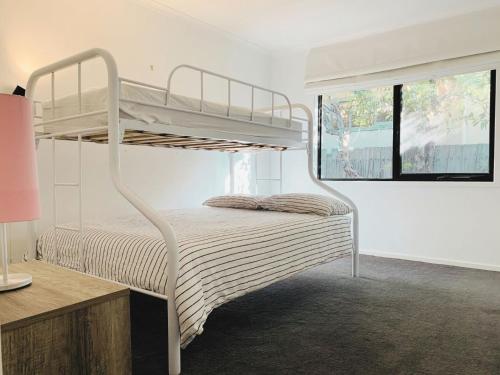 a white bunk bed in a room with a window at Buckley s 10 in Point Lonsdale