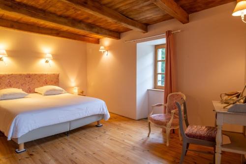 a bedroom with a bed and a desk and a chair at Ecogîte cévénola 3 personnes in Molezon