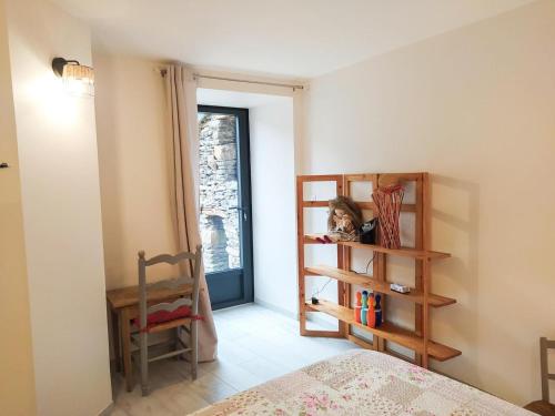 a bedroom with a bed and a book shelf and a window at Maison de l'aire in Fraissinet-de-Fourques