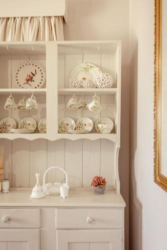 a white hutch with plates and dishes on it at 'Videre' in Rylstone