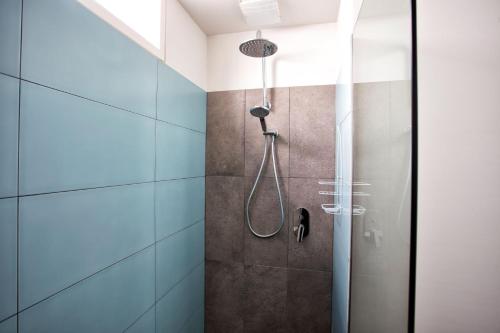 a shower in a bathroom with blue tiles at Bella Casa in Queenscliff