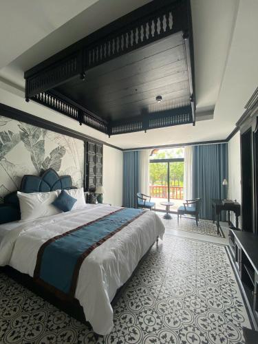 a bedroom with a large bed and a large window at Le Dung Hotel in Tam Kỳ