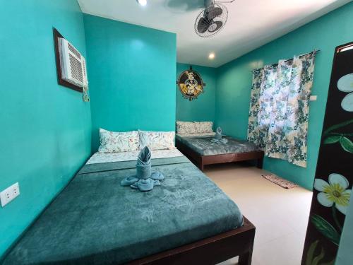 a room with two beds and a blue wall at Chef Panyang Beach Resort Okoy in Ocoy