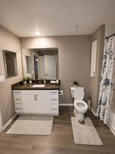a bathroom with a toilet and a sink and a mirror at Universal Stays Hollywood-Seconds to Universal Studios in Los Angeles