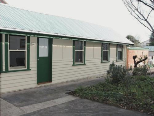 a white and green house with a green door at Doongarra in Queenscliff