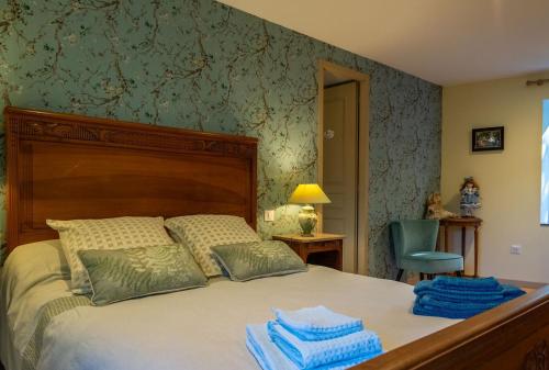 a bedroom with a bed with blue towels on it at La maison d'anna in Langogne