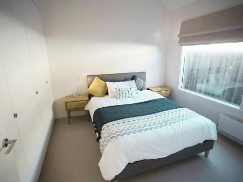 a bedroom with a bed and a window at Galway Cottage in Queenscliff
