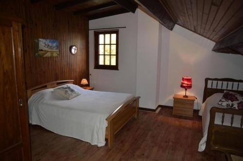 a bedroom with a white bed and a window at La parrot en margeride in Pierrefiche