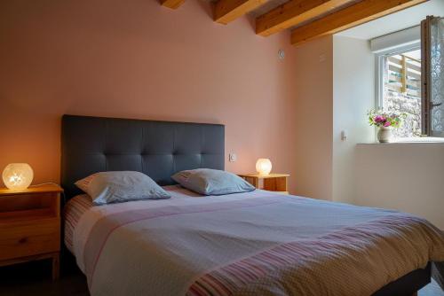 a bedroom with a large bed with two pillows at La maison de clémence 6 personnes in Mialanes