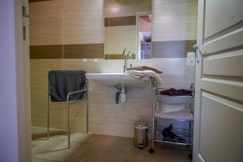 a bathroom with a sink and a mirror at La maison de clémence 6 personnes in Mialanes