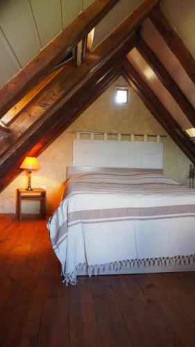 a bedroom with a white bed in a attic at La maisonnette in Marvejols