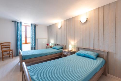 a hotel room with two beds and a chair at Gîte du boy 8 personnes in Lanuéjols