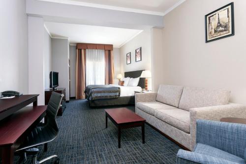 a hotel room with a couch and a bed at Wingate by Wyndham Athens GA in Athens