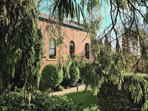 a red brick building with trees in front of it at Intermission in Queenscliff