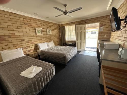 a hotel room with two beds and a television at Starlight Motor Inn in Roma