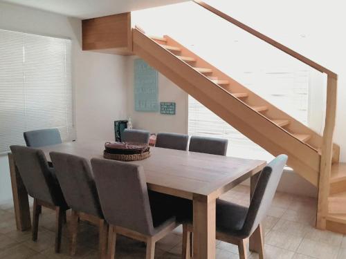 a dining room table with chairs and a staircase at Lonsdale Shores in Point Lonsdale