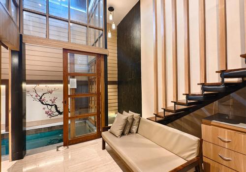 a living room with a couch and a staircase at Ohana Suites Yogyakarta in Yogyakarta