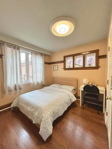 a bedroom with a bed and a desk with a chair at TORONTO Midtown HomeHaven in Toronto
