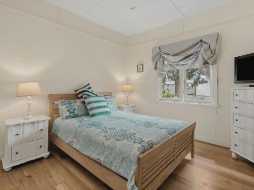 a bedroom with a bed and a window at Maison Cottage in Queenscliff