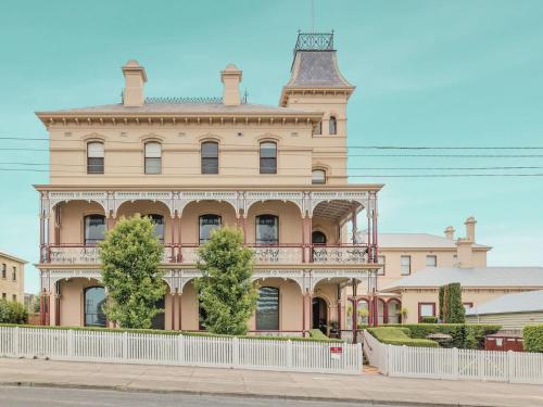 ein großes rosa Gebäude mit einem Turm oben drauf in der Unterkunft Ozone Tower in Queenscliff