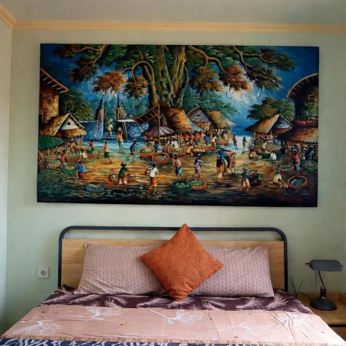a painting on the wall above a bed at Kubumade in Sanur