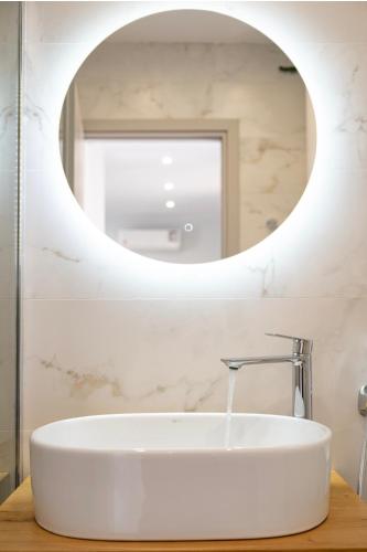 a bathroom with a white sink and a mirror at Rhea Central Luxury Apartment in Samos