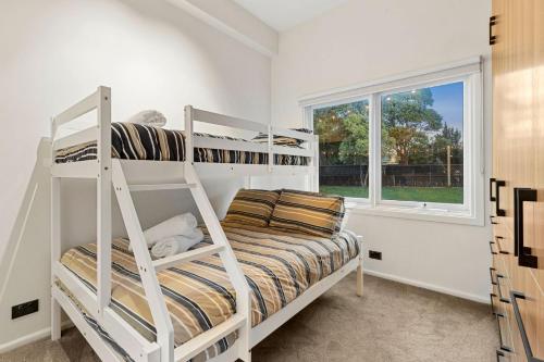 a bedroom with two bunk beds and a window at The Springs in Point Lonsdale