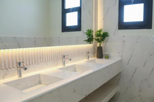 a bathroom with two sinks and a mirror at هلا شاليه اتين in Salalah