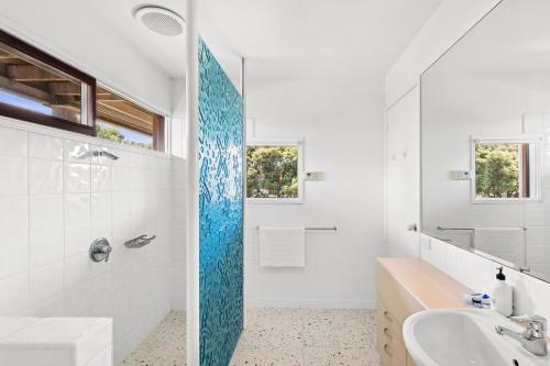 a bathroom with a tub and a sink and a mirror at The Beach House in Point Lonsdale