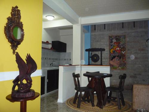 - une salle à manger avec une table, des chaises et un miroir dans l'établissement ApartaHotel Tierras Amazonicas, à Leticia
