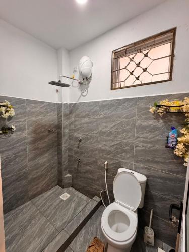 a bathroom with a toilet and a shower with a window at Homes by Najma in Mtwapa