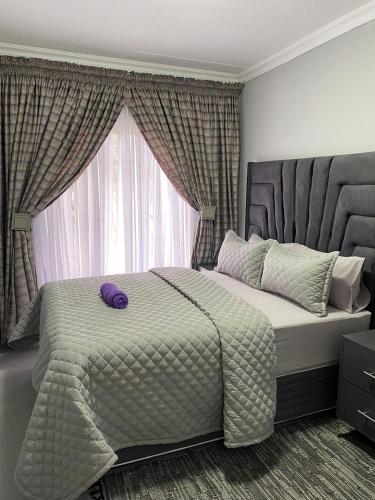 a bedroom with a large bed and a window at Smileys accomodation in Standerton