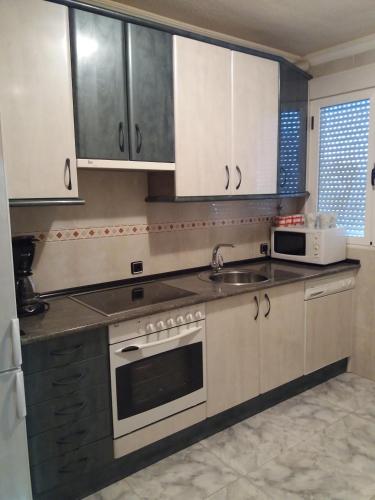 a kitchen with white cabinets and a sink at Casa Rural Amelia in Cepeda
