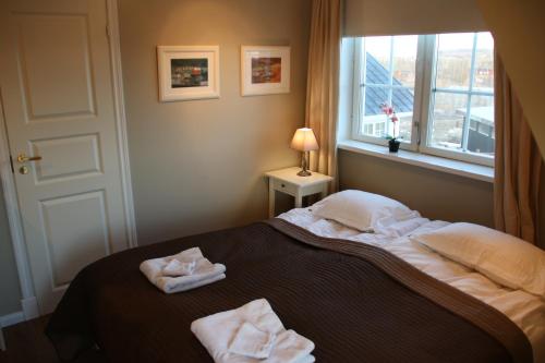 a bedroom with a bed with two towels on it at The White House in Reykholt