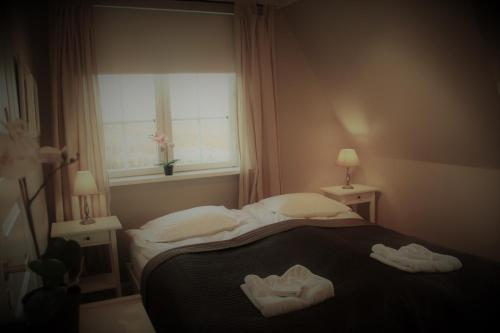 a bedroom with two towels on a bed with a window at The White House in Reykholt