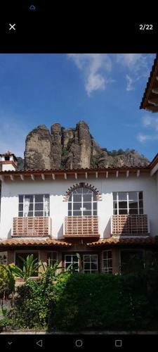a building with a rock wall on top of it at Casa Sauces in Tepoztlán