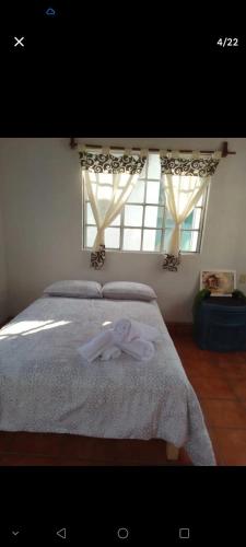 a bedroom with a bed with two towels on it at Casa Sauces in Tepoztlán