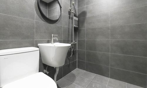 a bathroom with a white toilet and a mirror at Taean Manripo Feel Hotel in Taean