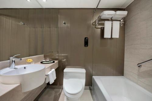 ein Badezimmer mit Toilette, Waschbecken und Badewanne in der Unterkunft The Kowloon Hotel in Hongkong