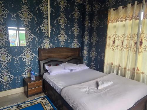 a bedroom with two beds with blue and gold wallpaper at Jhapali Hotel and lodge in Simra