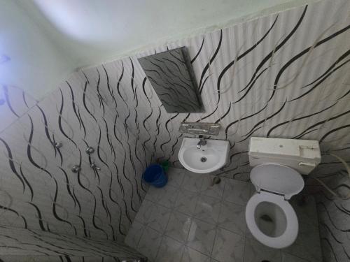 a bathroom with a toilet and a sink at Jhapali Hotel and lodge in Simra