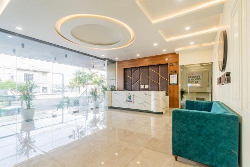 a lobby with a blue chair in a building at Treebo Indus in Jaipur