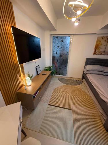 a bedroom with a bed and a flat screen tv at Azure North MiCasa in San Fernando