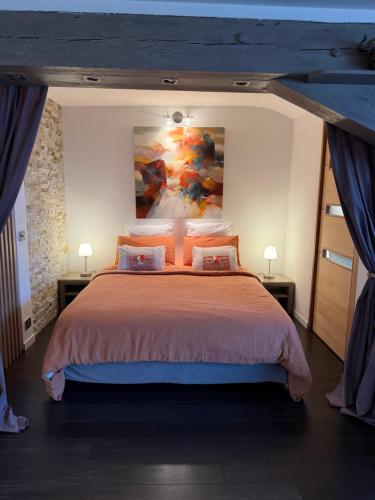 a bedroom with a large bed with a painting on the wall at Appartement Loft Cannes in Cannes